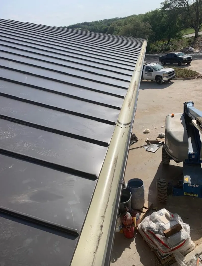 Standing seam panel and gutter detail on a metal roofing jobsite in Thibodaux